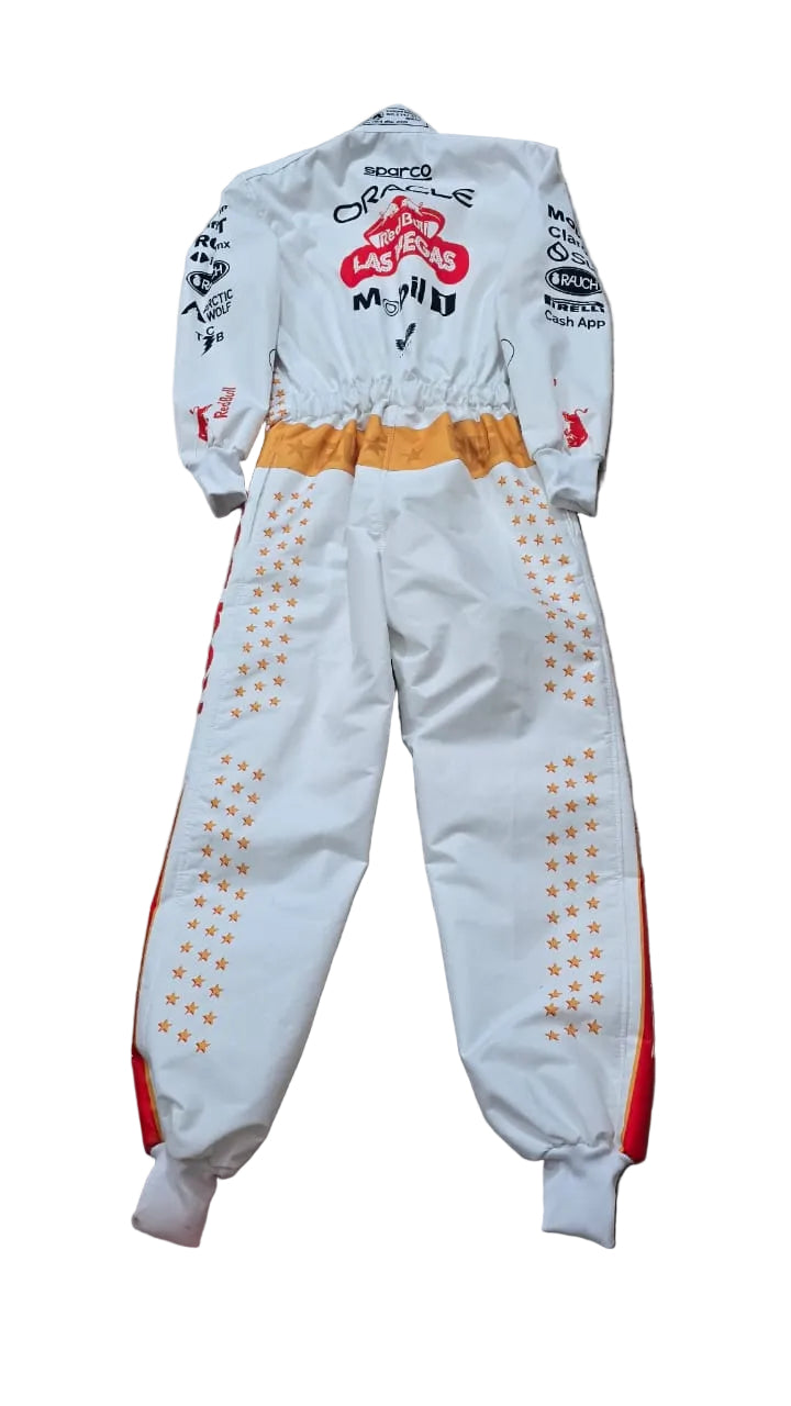 A white one-piece racing suit with orange and red accents, laid flat on a beige tiled floor. The suit features various sponsor logos and graphics, including 'Cruze' and 'Minghetti' on the back.