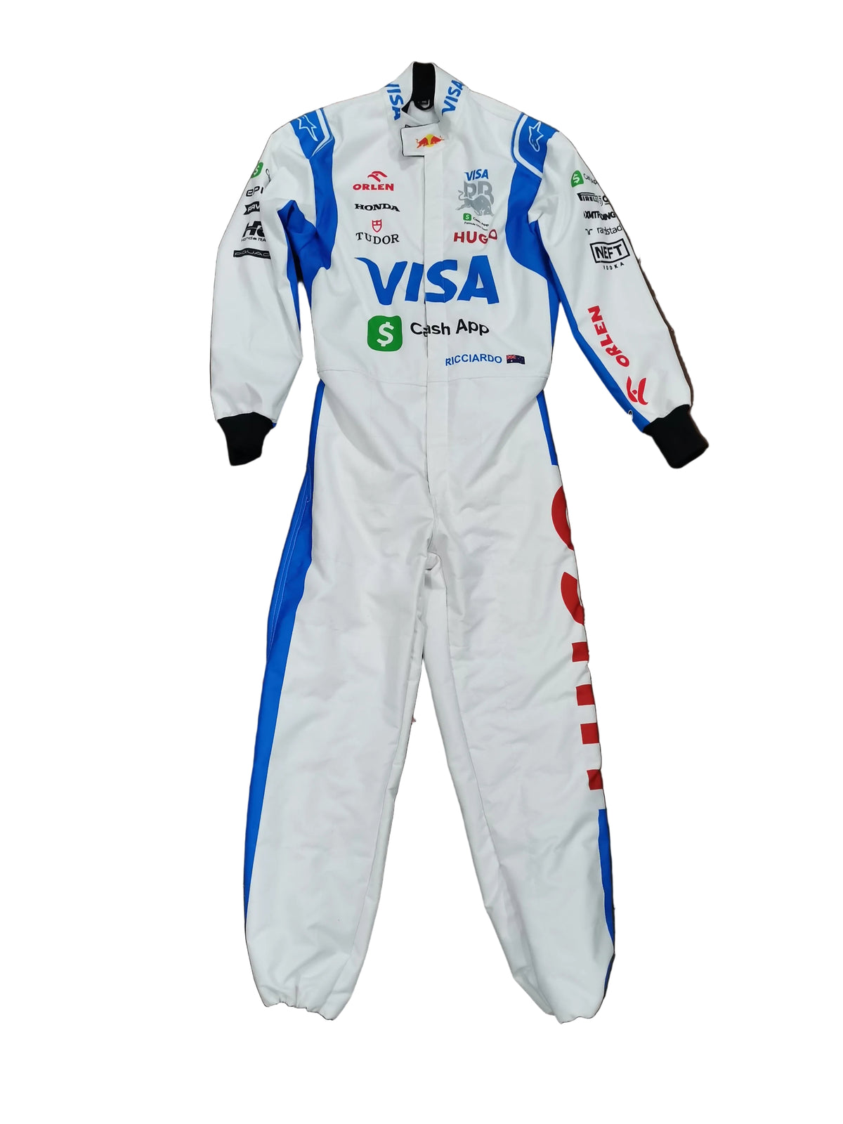 A white racing suit with blue and red side panels and various sponsor logos, laid flat on a brown floor.