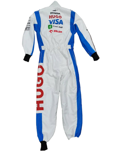 A white one-piece racing suit with blue and red sponsor logos, laid flat on a brown surface.