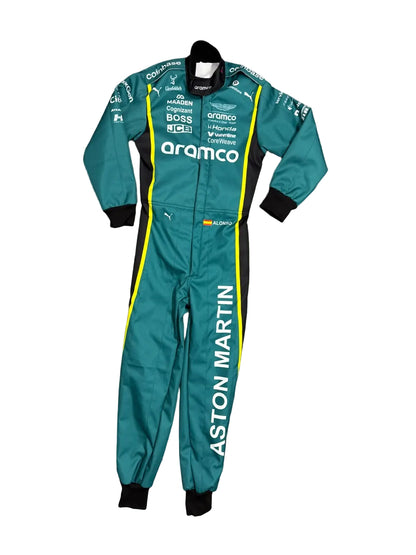 Aston Martin racing suit in teal green with black and yellow accents, laid flat on a gray marble floor. The suit features prominent sponsor logos including Aramco, Mercedes, and Puma, and 'ASTON MARTIN' printed vertically down the left leg.