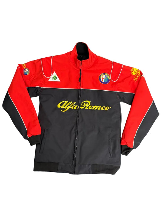 A red and black Alfa Romeo track jacket laid flat on a blue sheet, with the brand name in yellow script across the chest and team crests on the sleeves and chest.
