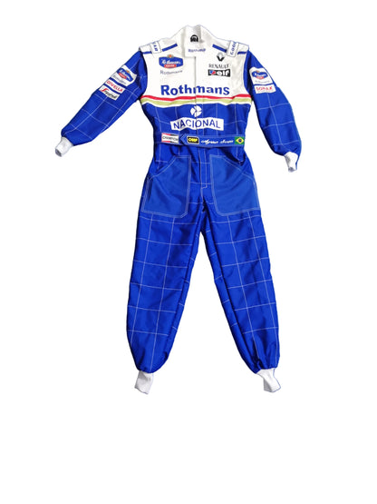 A blue and white long-sleeve racing suit laid flat on a wrinkled blue sheet, with visible sponsor logos including Rothmans, National, and BMW. Bare feet are visible at the bottom corners.