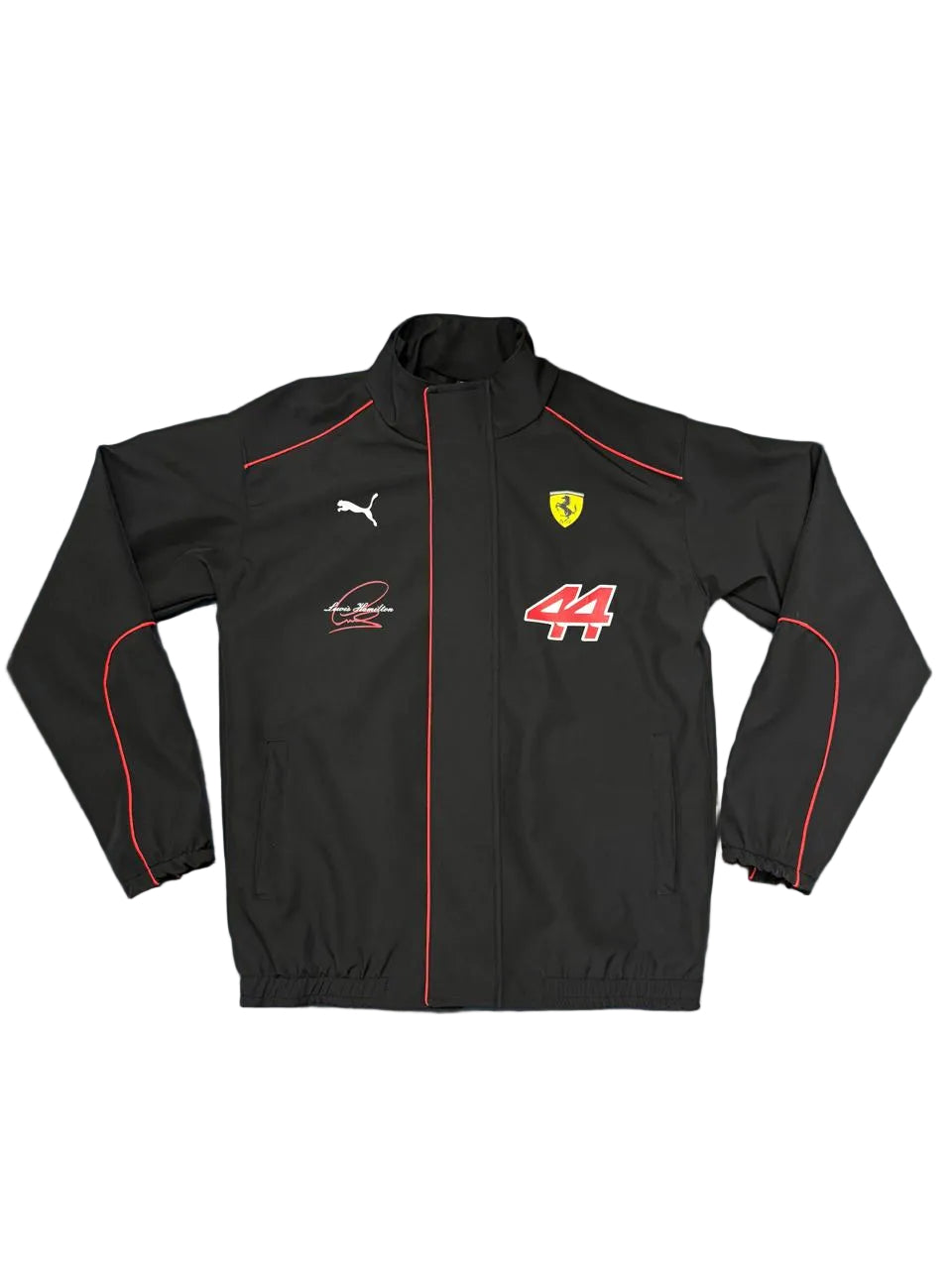 A black Puma Ferrari racing jacket with red piping, the Scuderia Ferrari logo, and the number 44, laid flat on a blue sheet.