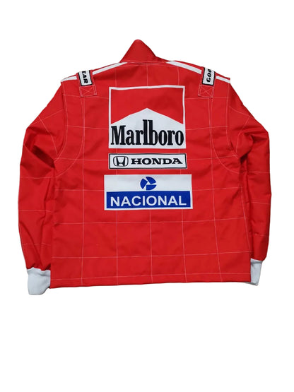 A red racing jacket with white grid lines, featuring sponsor logos for Marlboro, Honda, and Nacional on the back, laid flat on a textured beige stone surface.