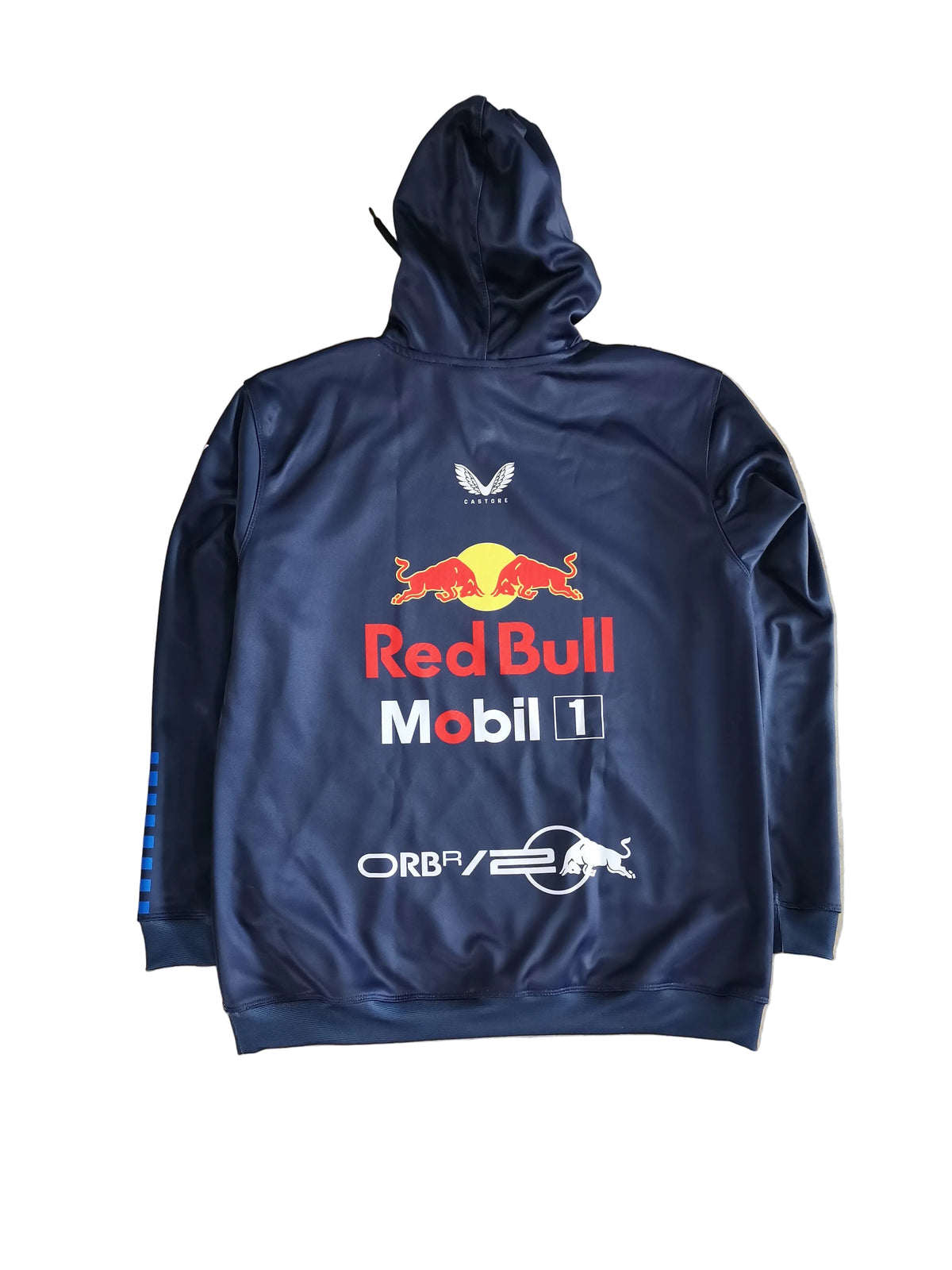 A navy blue Red Bull Racing hooded sweatshirt laid flat on a beige marble-patterned floor, featuring the Red Bull logo, Mobil 1 branding, and other sponsor logos on the back.