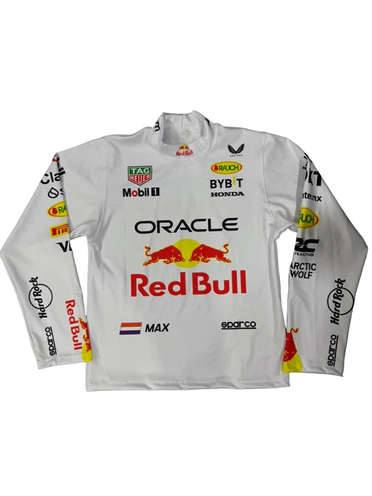 A white long-sleeve Oracle Red Bull Racing team shirt with various sponsor logos, laid flat on a gray marble floor. The shirt features the prominent Red Bull logo in the center, with other visible brands including Mobil 1, BYBIT, and Harley-Davidson.
