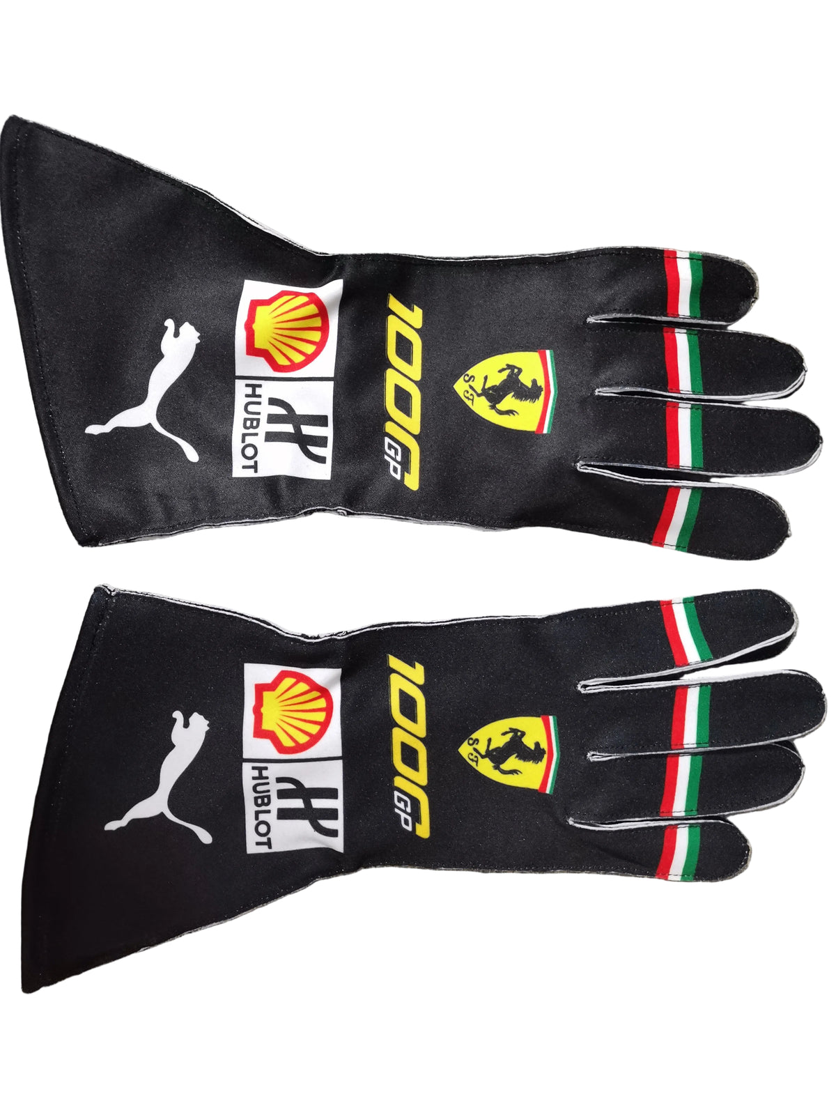 A pair of black Puma Ferrari 100 GP gloves laid flat on a gray textured surface. The gloves feature white Puma logos, yellow Shell and Ferrari branding, the Italian flag stripes on the fingers, and Hublot logos on the backs.