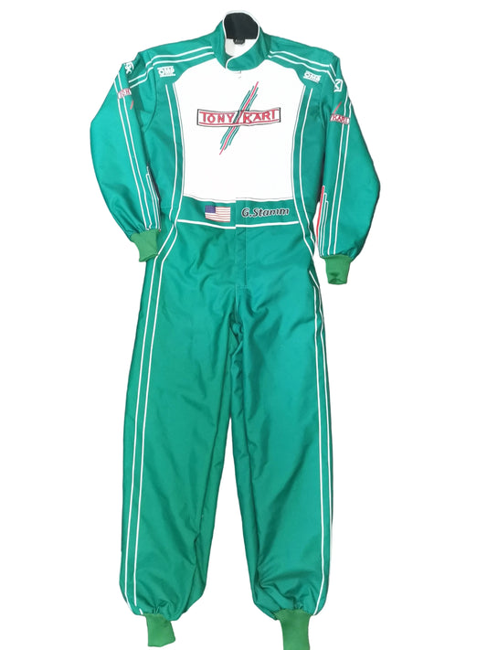 A green and white racing suit laid flat on a black fabric background, featuring a white chest panel with a red and blue 'Tony Kawasaki' logo, green cuffs and leg openings, and white side stripes.