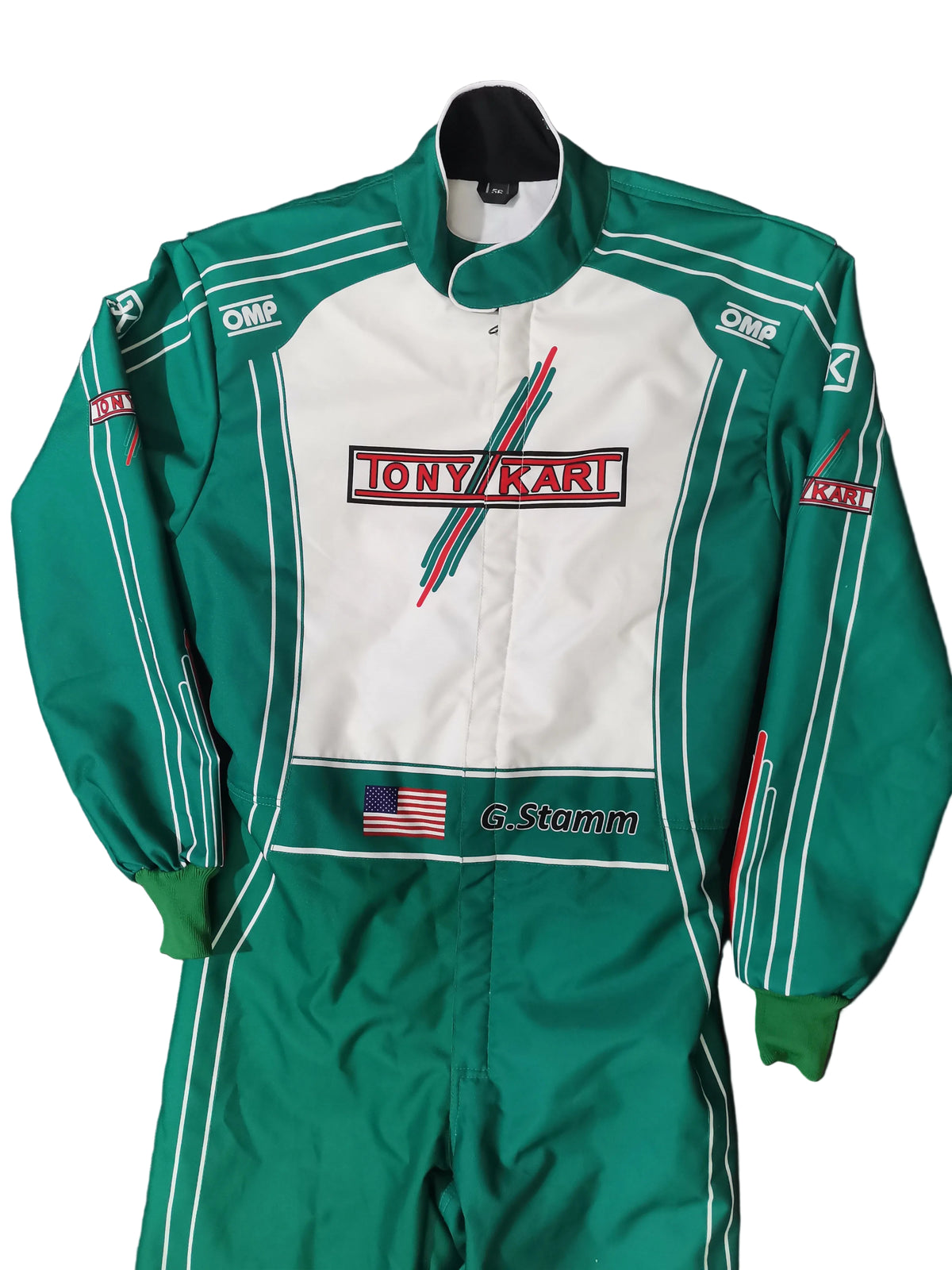 A green and white Tony Karl / G. Stamm racing suit laid flat on a black background.