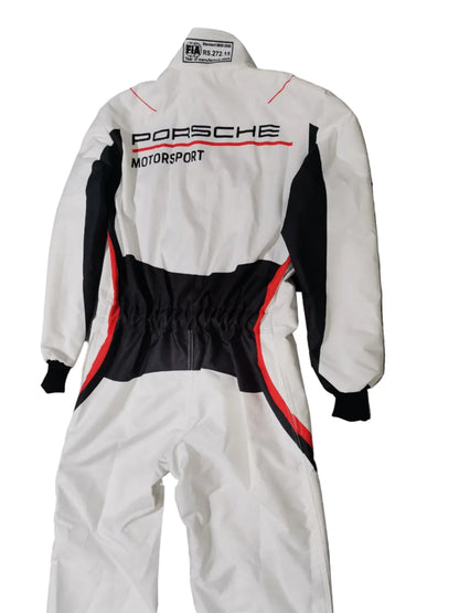 A white one-piece racing suit with black and red accents, featuring 'PORSCHE MOTORSPORT' printed vertically on the back, laid flat on a gray marble-patterned floor.
